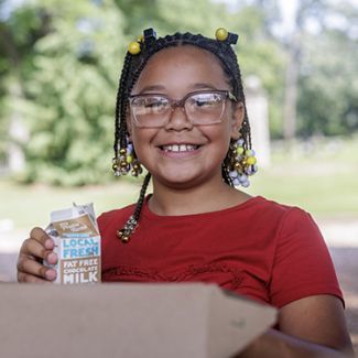 Jalissa holding a carton of milk. 