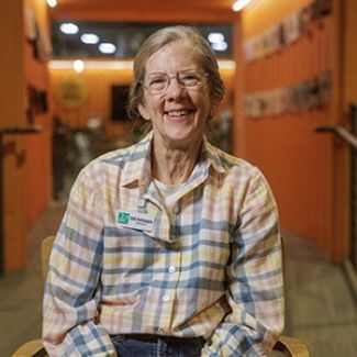 Deb sitting on a chair while smiling.