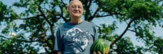 Older man at senior food pantry holding a watermelon