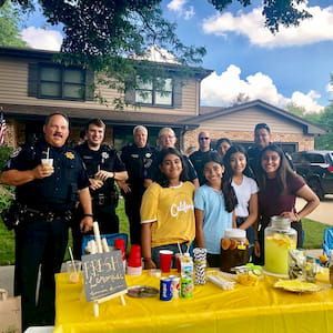 Alizay, Emaan, and police officers at lemonade stand