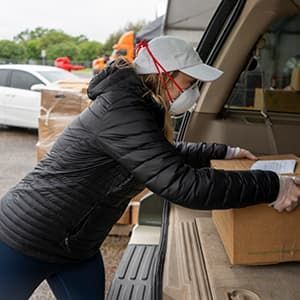Volunteer loading food into car