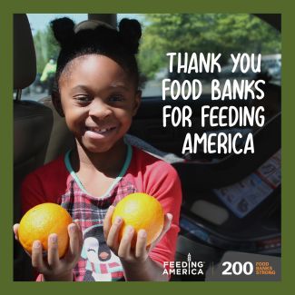 A happy girl holding two oranges