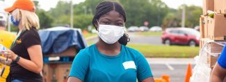 Food bank volunteer wearing masks carrying boxes