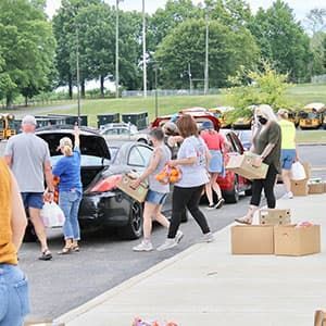 Volunteers loading food into cars