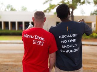 Southeastern Grocers volunteers wearing shirts that says "Winn Dixie Gives" and "Because No One Should Be Hungry"