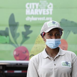 Omega, a driver with City Harvest, in front of the truck she uses to pick up and deliver food donations