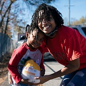 Courtney and 4-year-old Carter hugging in the parking lot of a food pantry