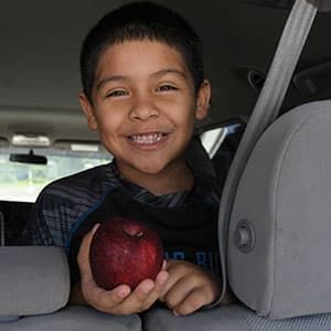 Child with an apple at a mobile pantry