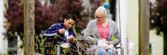 Photo of a woman and her son, sitting on a bench