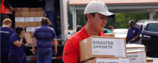 A volunteer carrying disaster relief boxes.