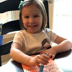 A young girl makes a card