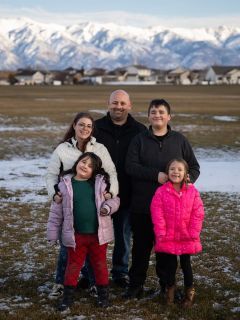 A family of five standing outside on a winter's day.
