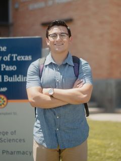 Thomas standing in front of a university building.