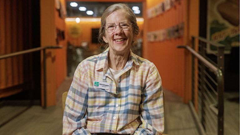 Deb sitting on a chair while smiling.