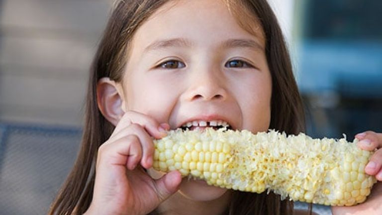 Girl eating corn.