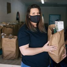 Photo of a food bank worker holding a bag of food.