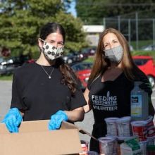 Mother and daughter volunteering at mobile pantry.