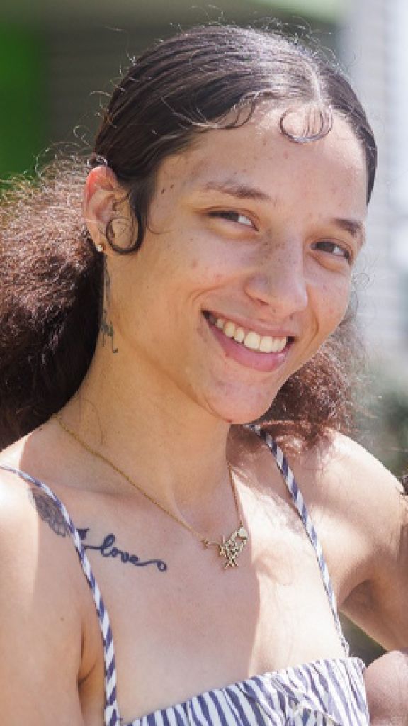 A woman smiling wearing a striped dress