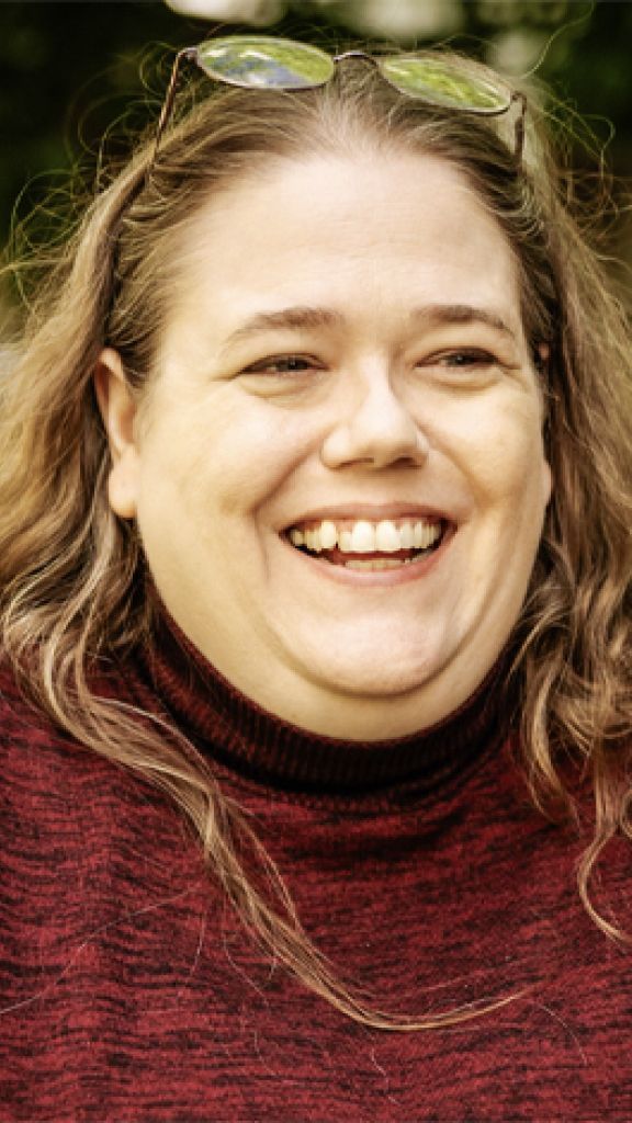 A person in a red sweater smiling