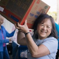 Food pantry worker carrying a box of food in Yorba Linda, California