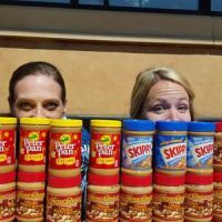 Cheesecake factory employees collect peanut butter for their food drive.