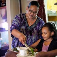A mother serving her child soup.