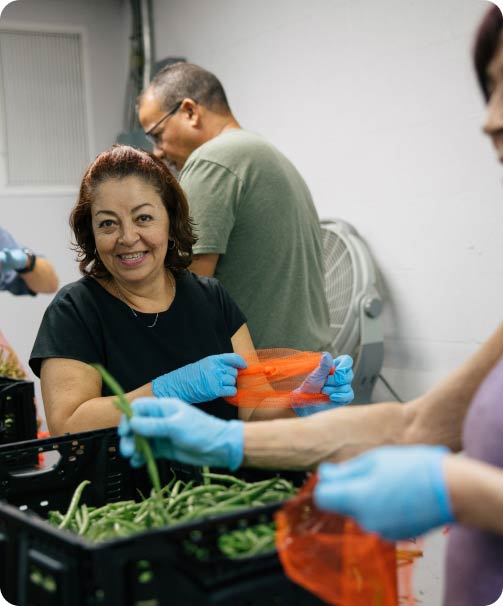 A smiling woman working at a food bank.