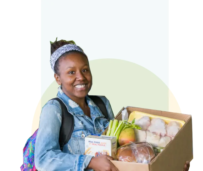 A smiling woman with a box of fresh produce.