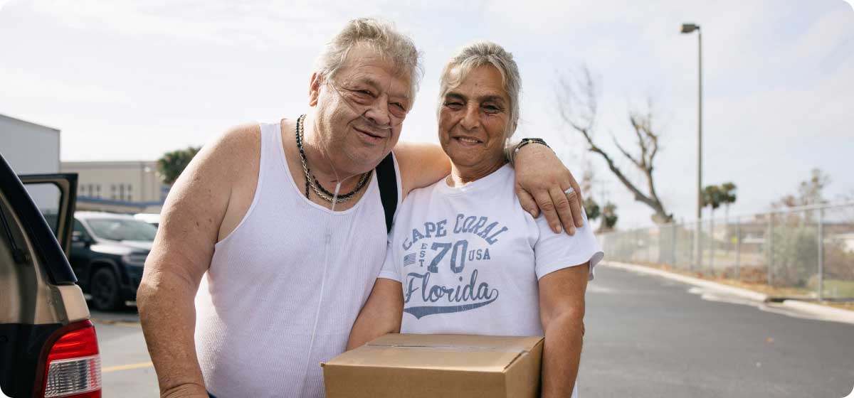 An elderly couple smiling after visiting a pantry.